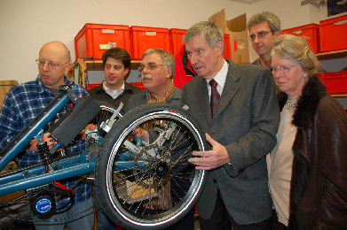 In der Werkstatt der Firma USED erkl�rte Gesch�ftsf�hrer Bob Giddens (links) der Besuchergruppe rund um den Landtagsabgeordneten Coenen (4. von links) die Funktionsweise des �Scooter-Trike�.
